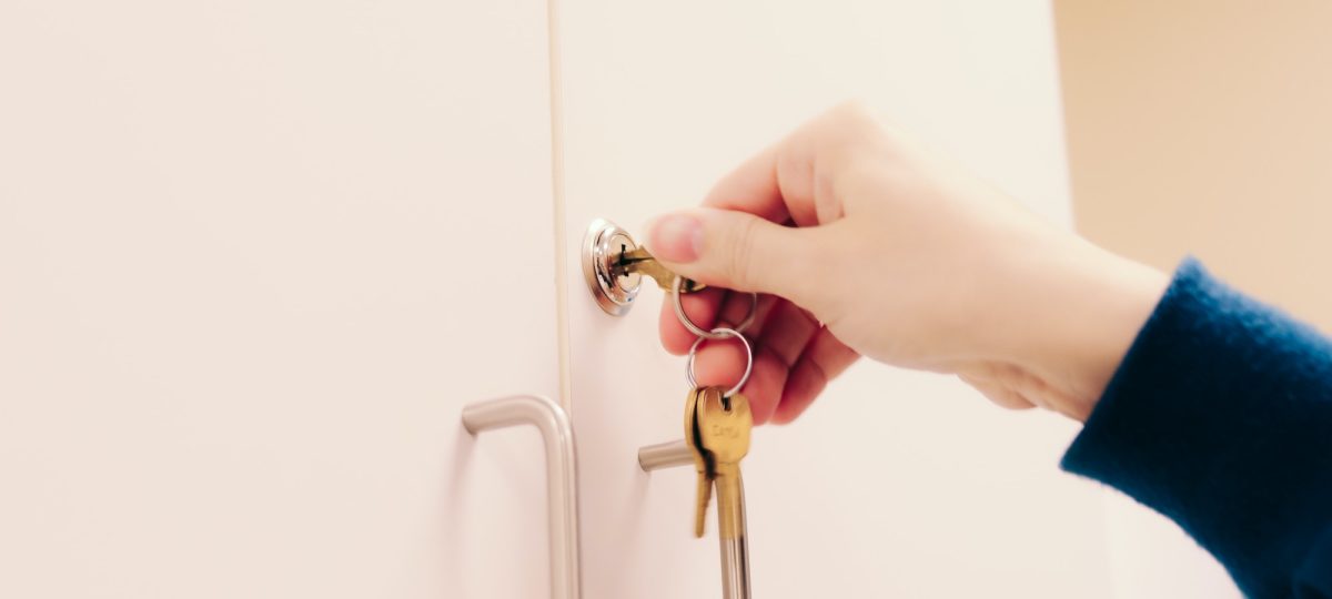 A female locking a cabinet showing us how to childproof your house.