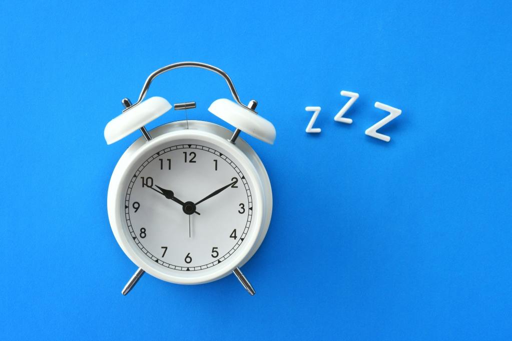 Alarm clock with ZZZ with a blue background.