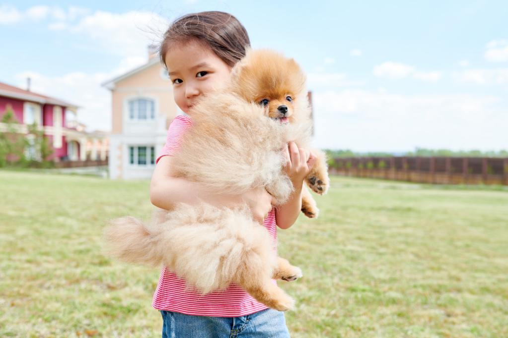 Girl hold up her dog.