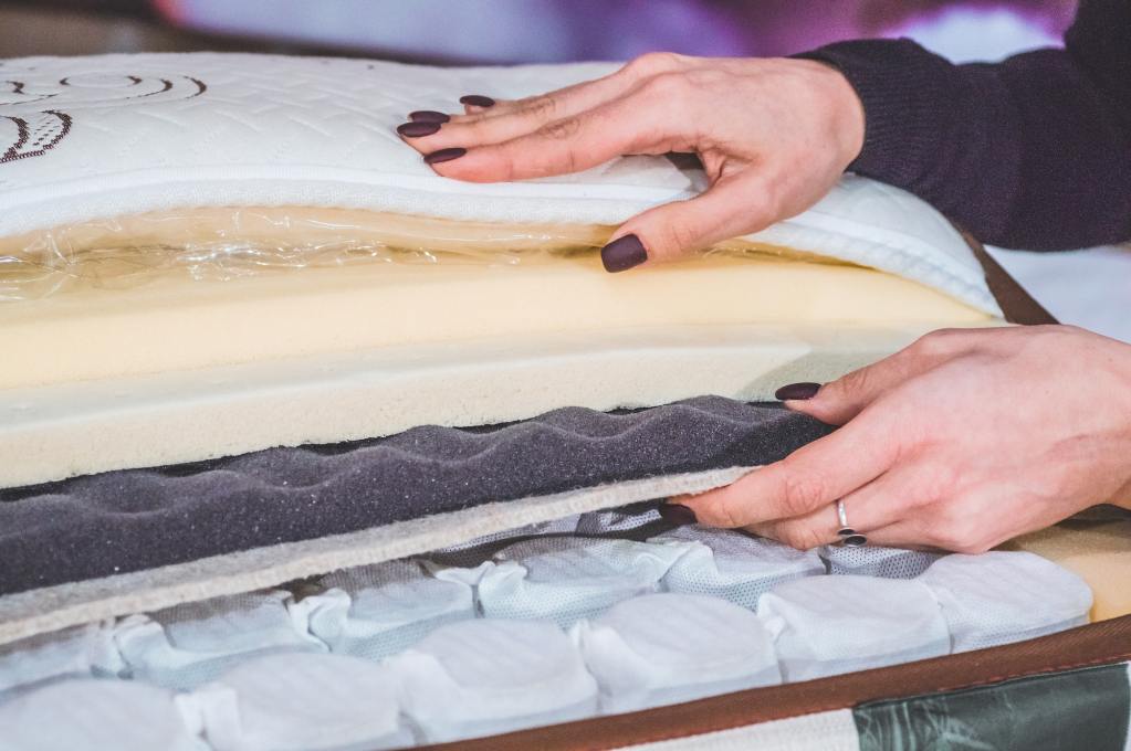 Woman examines the difference between memory foam and latex.