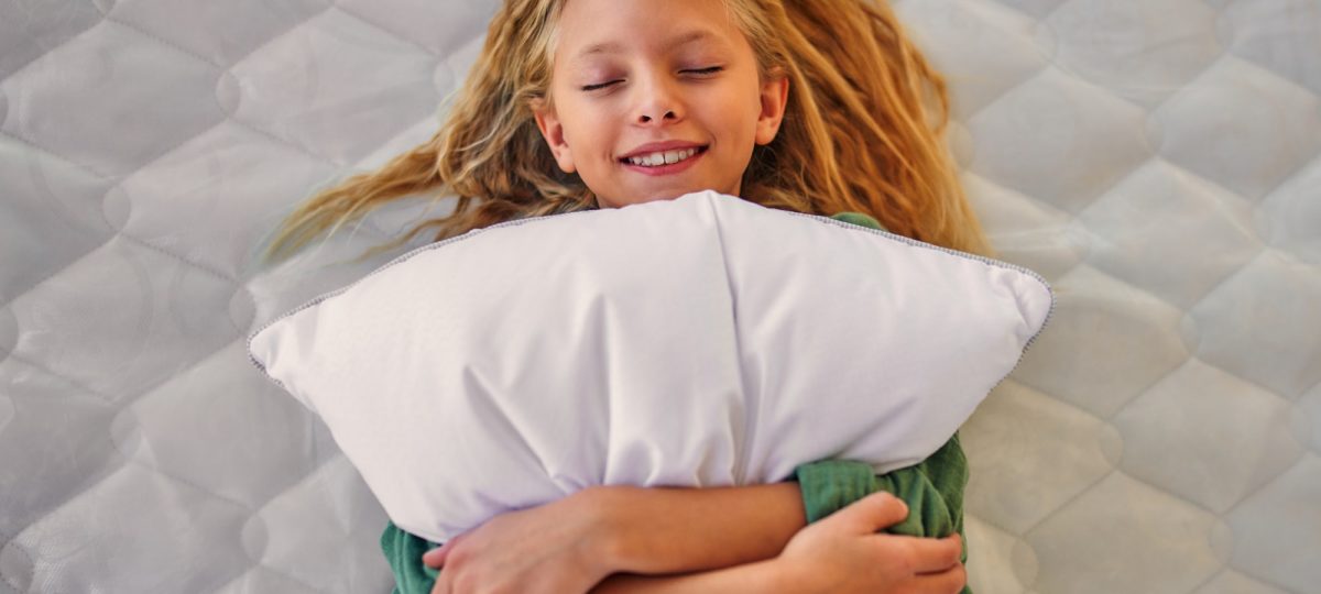 Girl laying with a pillow. A Good Bed And Pillow.