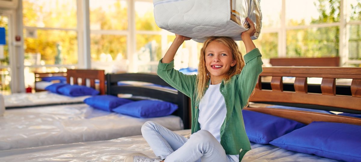 Kid playing on a smart mattress in the store.