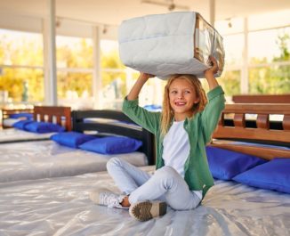 Kid playing on a smart mattress in the store.