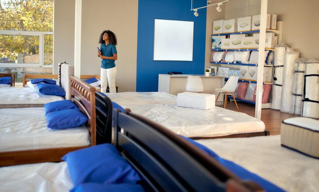 Mattress saleswoman looking at all of the high-quality bedding.