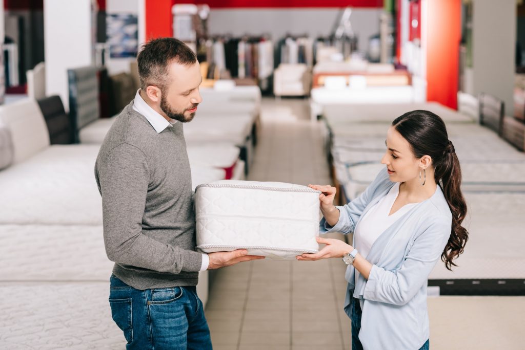 What Is The Normal Thickness Of A Mattress & Boxspring. Couple checking mattress thickness.