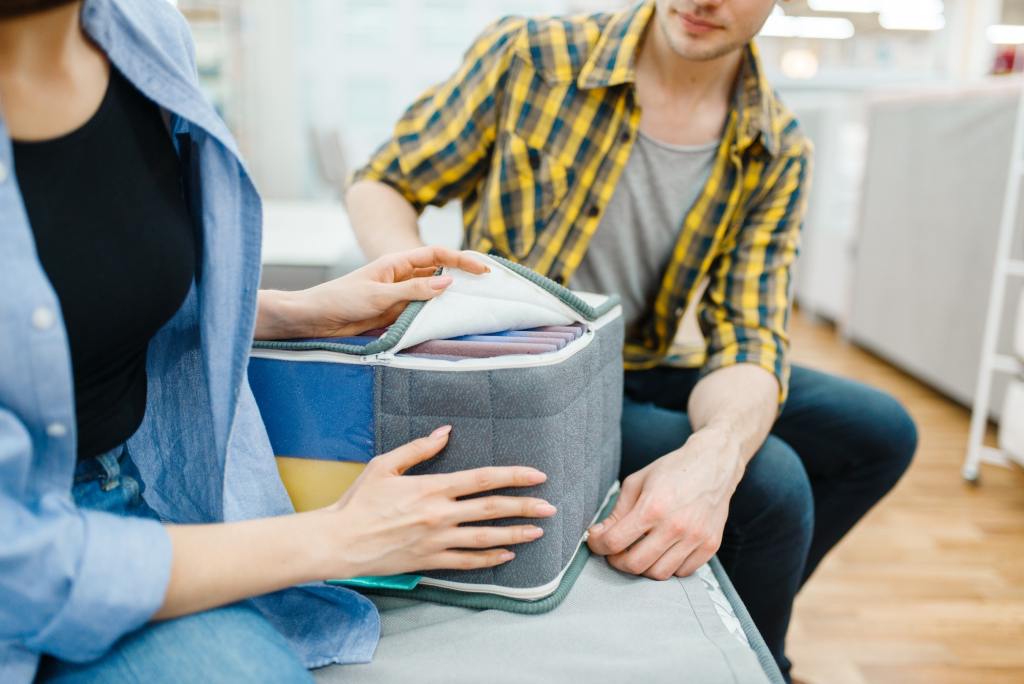 Couple choosing mattress and pillow from STL Beds.