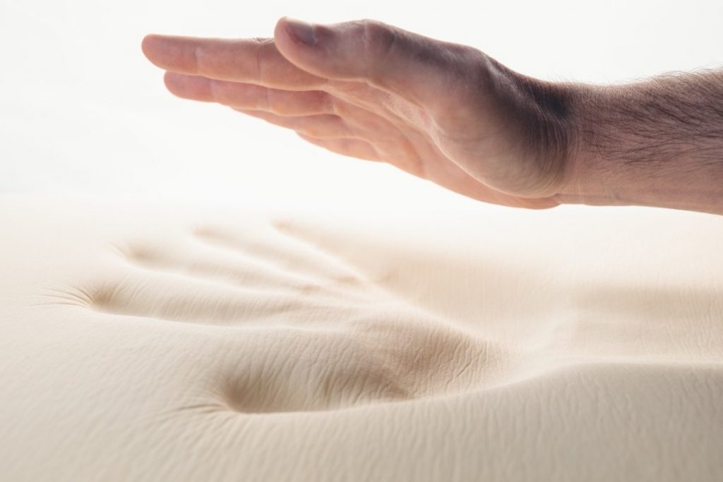 Why College Students Need A Good Mattress. Foam mattress with a hand print.