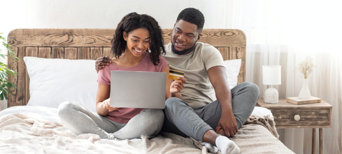 Couple sitting in their new bed.