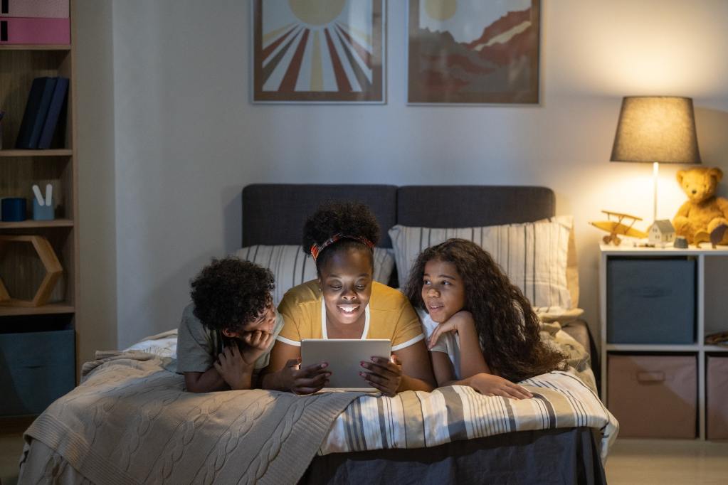 Happy Mother Reading To Kids Before Bedtime