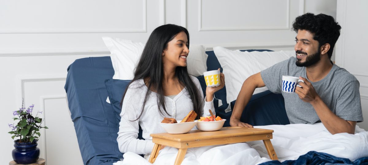 a couple having breakfast in an adjustable bed