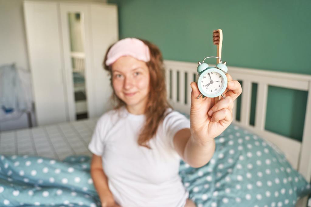 Morning routine. Woman waking up without snoozing.