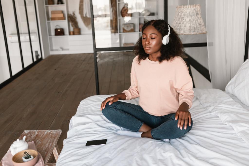 Relaxed woman meditating in her bed.