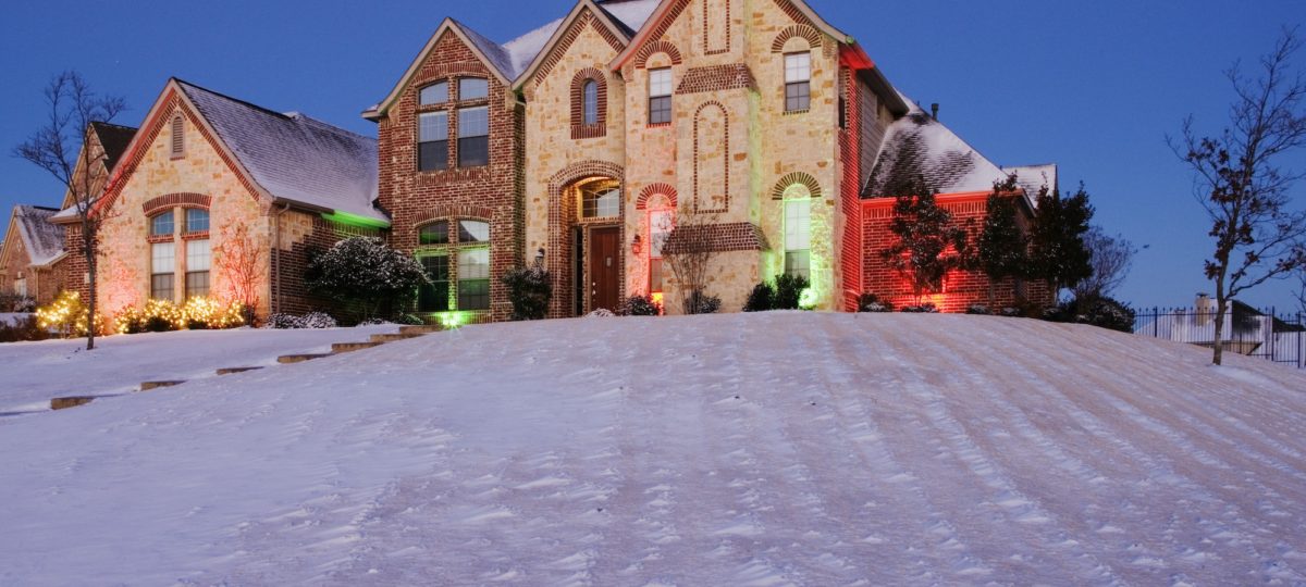 Snow Covered Yard and Stone House.