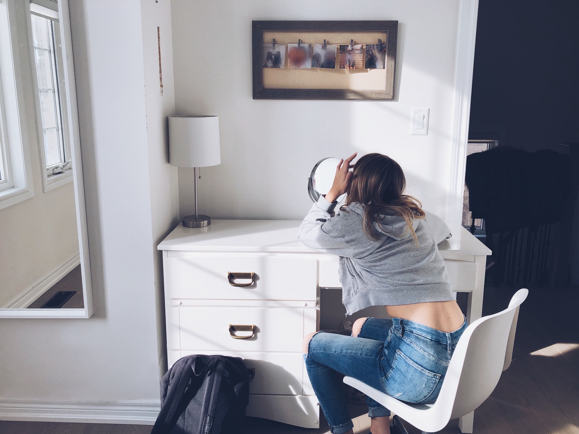 Teenage girl using light and mirrors to make the room look bigger.