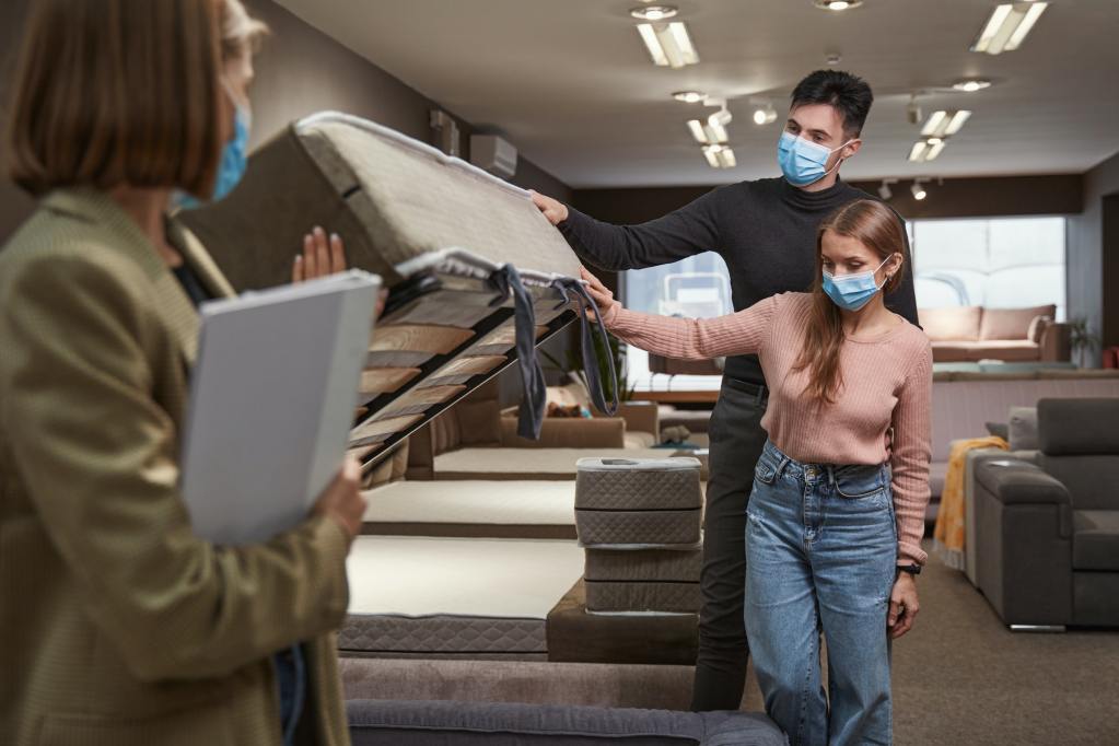 Salesperson explaining the difference between a regular and split box spring.